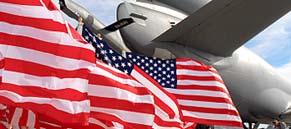 American Flags Flying Behind the tail of a Large Jet Plane